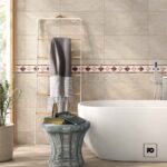 Modern bathroom scene with a freestanding white tub, towel rack, and a gray towel draped over wooden bars beside a wicker side table and books.