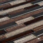 Malla30x30-almeria-cenezzia-2-ok | Plomería García Close-up of rectangular glass tiles in brown and beige tones arranged in parallel rows.