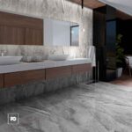 Piso porcelánico tipo mármol gris brillante imperia 80 × 160 cm-tendenzza-2-ok | Plomería García Modern bathroom with marble walls and floor, double vessel sinks on a white countertop, wooden vanity, a mirror, pendant lights, and a seating area with a plant in the background.