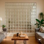 Living room with a wall of glass blocks, two gray sofas, a wooden coffee table, and potted plants.
