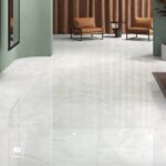 Xrddaft5nfpyno405j2914237767754831801t23111023 | Plomería García Modern hotel lobby seating area with green walls, light marble floor, and two brown leather chairs around a small round black table under brown curtains.