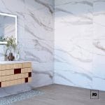 Modern bathroom corner with marble-tiled walls, a floating wooden vanity, and decorative vases beneath a backlit mirror inside a light-filled space