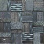 Malla decorativa jenner de vidrio y piedra gris 30 x 30 cm-tiles-ok | Plomería García Close-up of a dark gray stone tile mosaic with varied textures—smooth, grooved, and rough surfaces—featuring a small white pg logo in the bottom-left corner.
