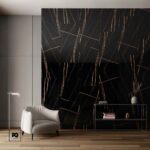 Piso porcelánico tipo mármol negro brillante barilé 60 × 120 cm-tendenzza-2-ok | Plomería García Modern living room featuring a black marble accent wall with gold veining, a gray cabinet wall, a white upholstered armchair, and a glass console table with books and a vase.