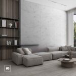 Modern living room with a gray sectional sofa, marble wall panels, open dark bookshelf, and round coffee tables by a large window with sheer curtains.